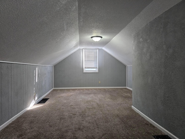 bonus room with carpet flooring, a textured ceiling, and vaulted ceiling