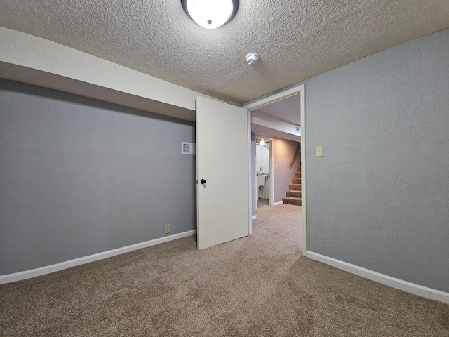 basement with a textured ceiling and carpet