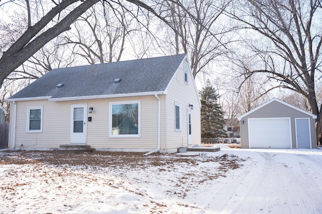 view of front of home featuring a garage and an outbuilding