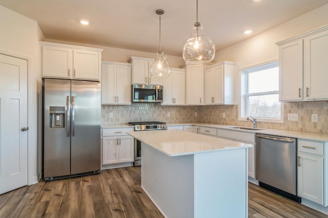 kitchen with hanging light fixtures, white cabinetry, sink, and appliances with stainless steel finishes