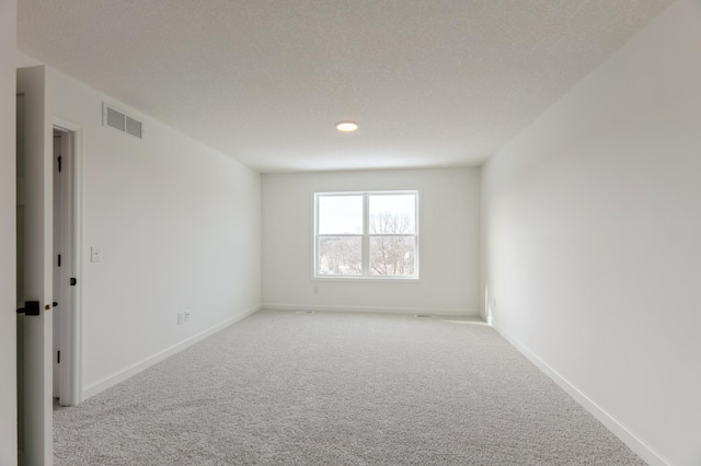 carpeted empty room with a textured ceiling