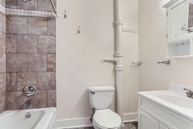 full bathroom with tiled shower / bath, vanity, and toilet