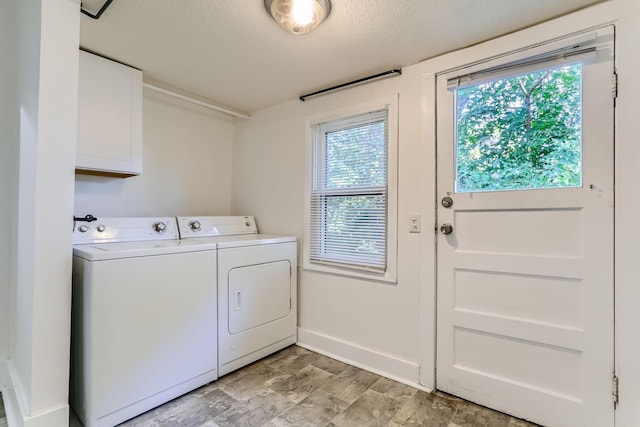 laundry room featuring a textured ceiling, cabinets, and independent washer and dryer