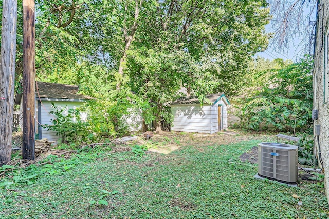 view of yard with central AC unit and a storage shed