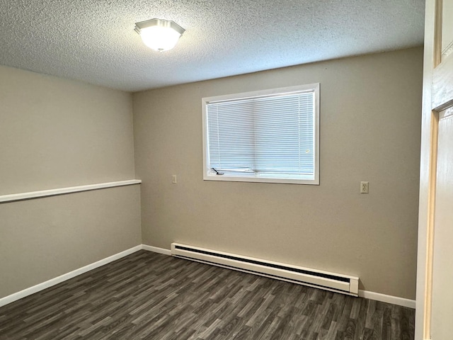 empty room with a textured ceiling, dark hardwood / wood-style flooring, and a baseboard radiator