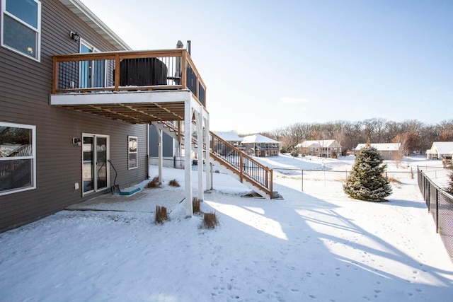 snowy yard with stairs, a deck, and fence