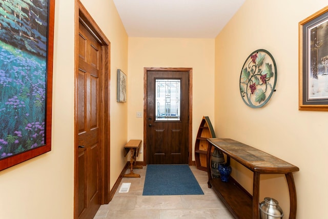 foyer with light tile patterned flooring, visible vents, and baseboards