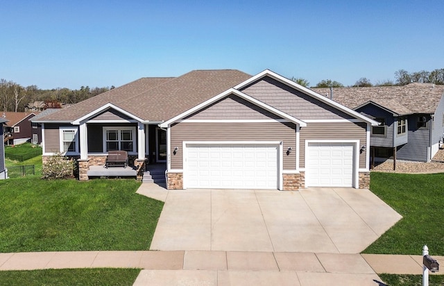 craftsman house featuring stone siding, concrete driveway, an attached garage, and a front lawn