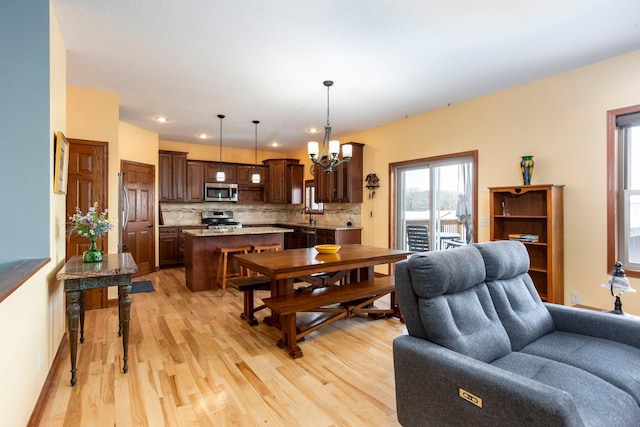 living room with light wood-style floors, a chandelier, and recessed lighting