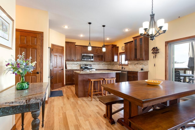 dining room with a notable chandelier, light wood finished floors, and recessed lighting