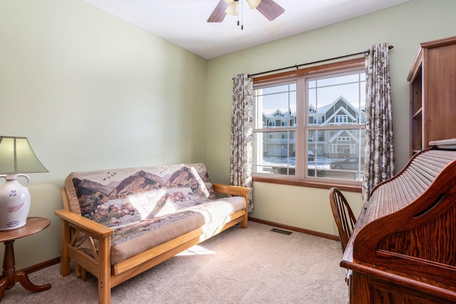 living area with carpet flooring, visible vents, baseboards, and ceiling fan