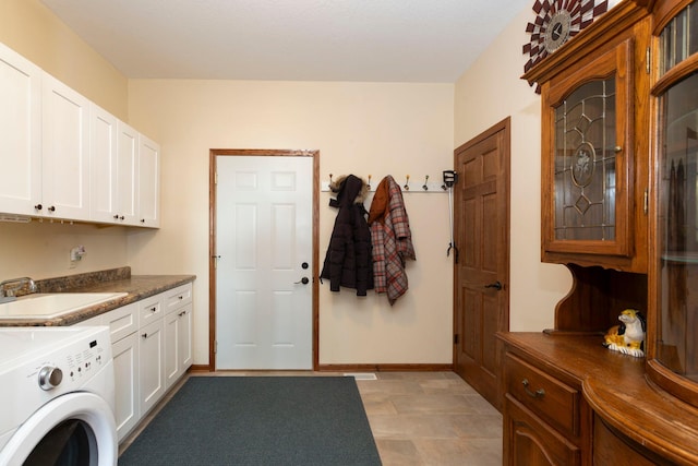 clothes washing area featuring baseboards, washer / dryer, a sink, and cabinet space