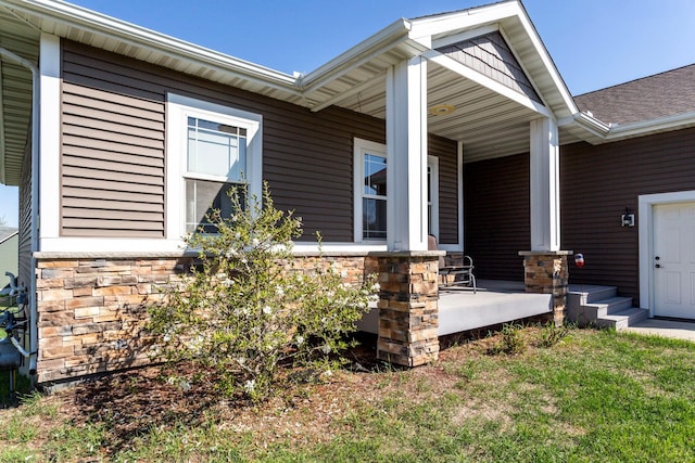 entrance to property with a porch and stone siding