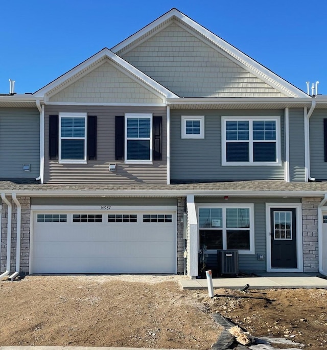 view of front of house featuring a garage and central air condition unit