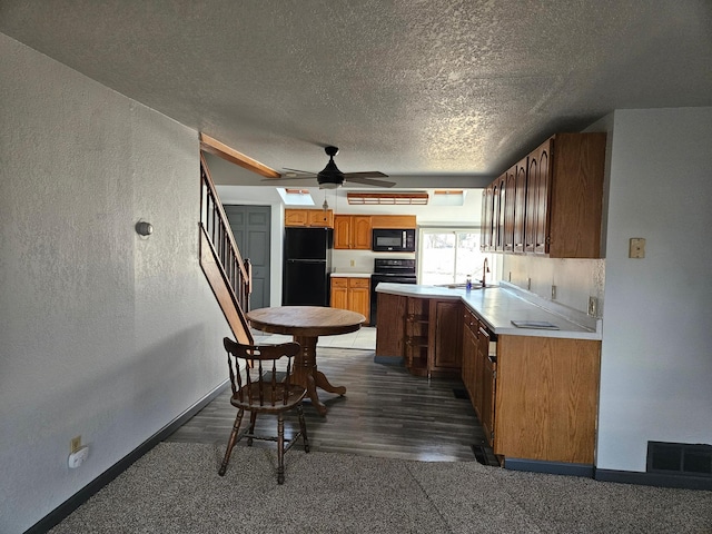 kitchen featuring sink, a textured ceiling, dark hardwood / wood-style floors, ceiling fan, and black appliances