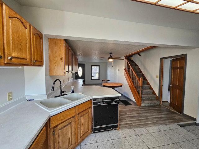 kitchen featuring sink, light tile patterned floors, dishwasher, kitchen peninsula, and ceiling fan