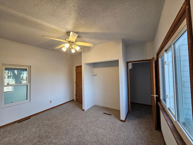 unfurnished bedroom with ceiling fan, carpet floors, and a textured ceiling