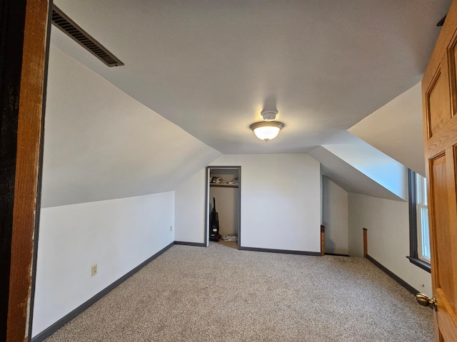 additional living space featuring vaulted ceiling and carpet