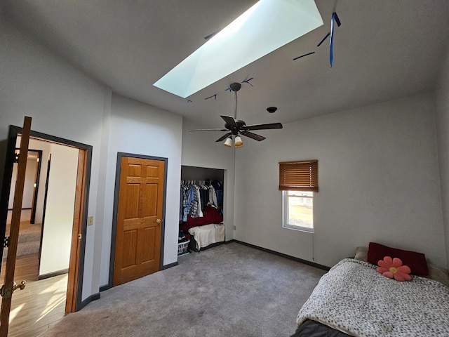 carpeted bedroom with a closet, ceiling fan, and a skylight