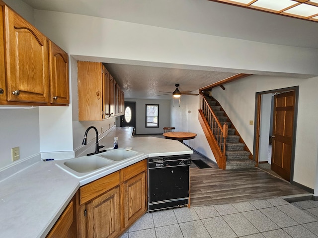 412 Prairie Ave, Faribault, MN 55021 - kitchen with dishwasher, a sink, brown cabinetry, light countertops, and light tile patterned flooring