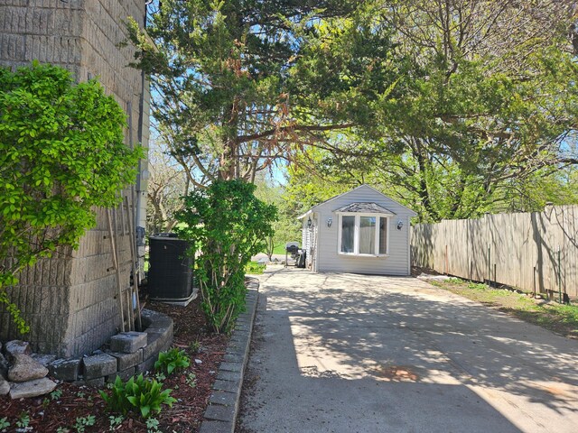 412 Prairie Ave, Faribault, MN 55021 - view of patio / terrace with central air condition unit, fence, driveway, and an outdoor structure