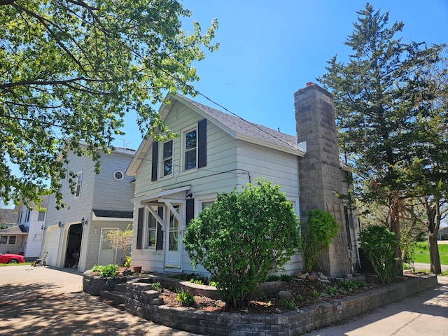 412 Prairie Ave, Faribault, MN 55021 - view of front of property with an attached garage, a chimney, driveway, and roof with shingles