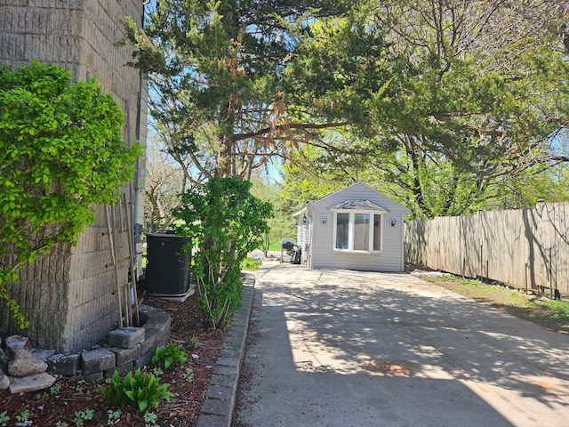 412 Prairie Ave, Faribault, MN 55021 - view of patio featuring central AC, fence, concrete driveway, and an outbuilding