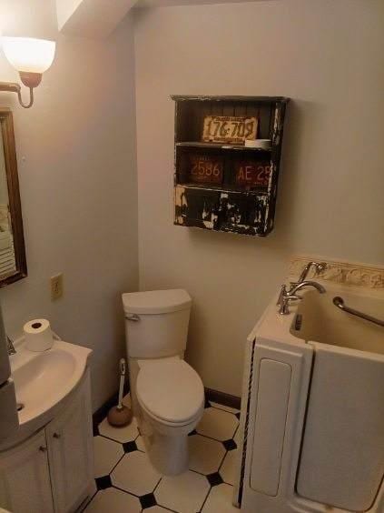 412 Prairie Ave, Faribault, MN 55021 - full bathroom featuring tile patterned floors, vanity, toilet, and a garden tub