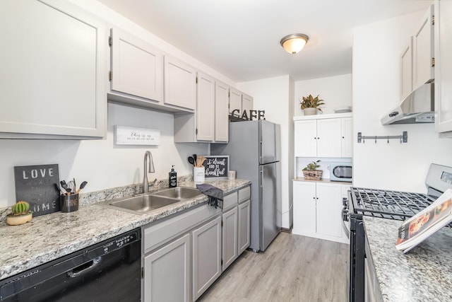 kitchen featuring appliances with stainless steel finishes, light hardwood / wood-style floors, wall chimney exhaust hood, white cabinets, and sink