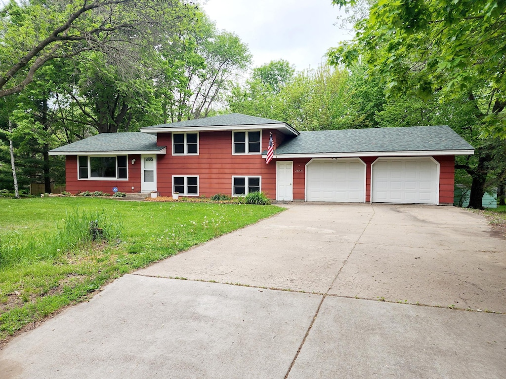 split level home with a garage and a front lawn