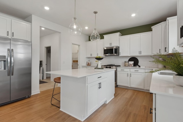 kitchen with white cabinets, pendant lighting, stainless steel appliances, and a kitchen island