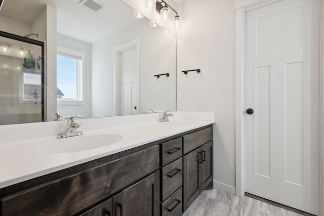 bathroom with a shower with shower door and vanity