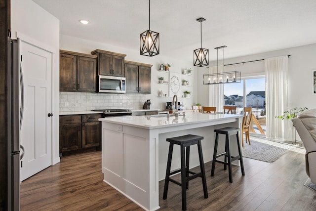 kitchen featuring sink, pendant lighting, a center island with sink, and stainless steel appliances