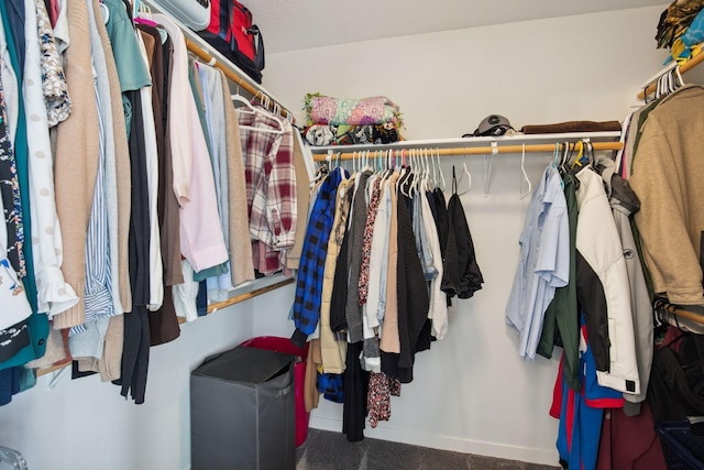 spacious closet featuring dark colored carpet