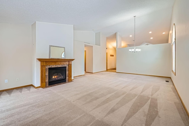 unfurnished living room featuring a textured ceiling, high vaulted ceiling, light colored carpet, an inviting chandelier, and a tiled fireplace