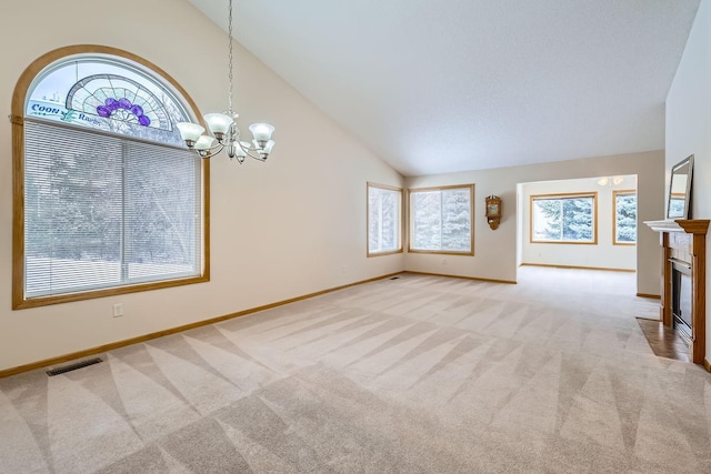 unfurnished living room featuring light carpet, an inviting chandelier, and high vaulted ceiling