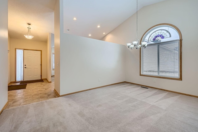 carpeted entryway featuring a notable chandelier and high vaulted ceiling