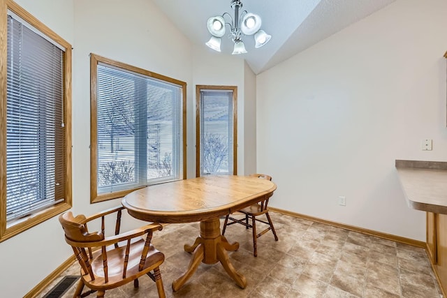 dining space with lofted ceiling and an inviting chandelier