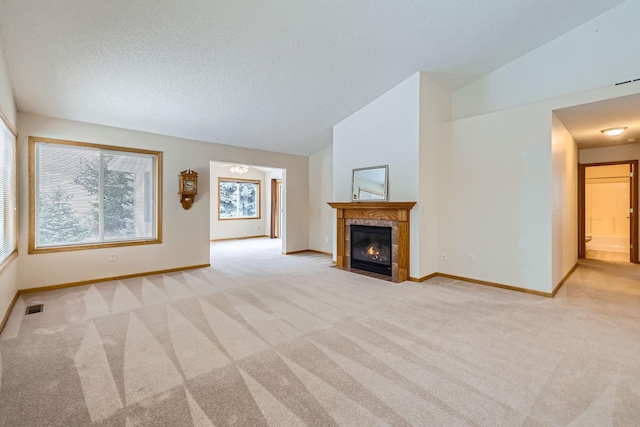 unfurnished living room with light colored carpet, a textured ceiling, and lofted ceiling