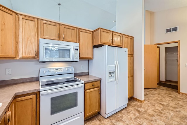 kitchen with high vaulted ceiling and white appliances