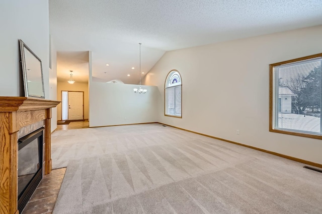 unfurnished living room featuring a textured ceiling, light colored carpet, vaulted ceiling, and a notable chandelier