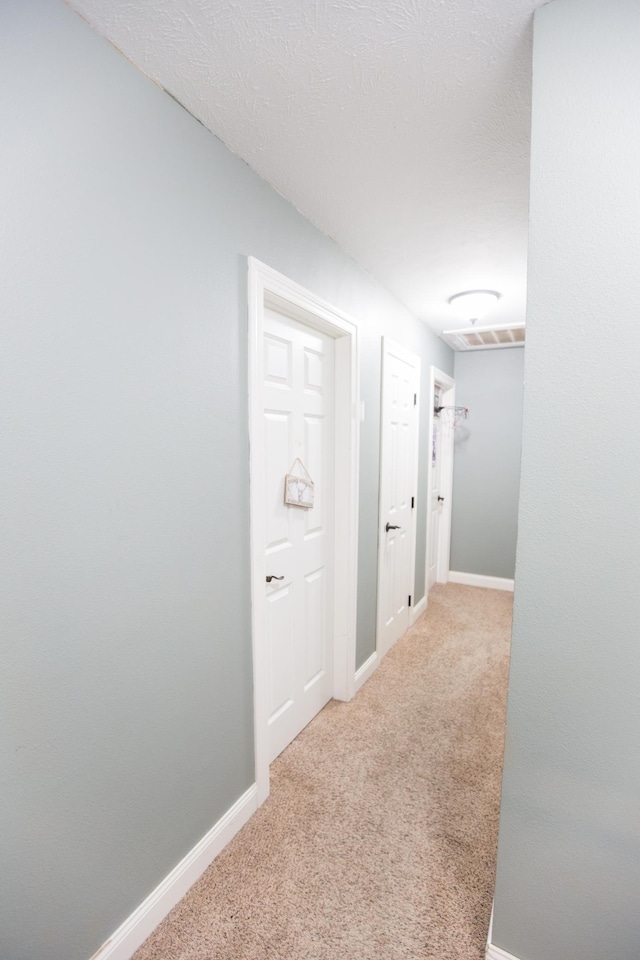 hallway featuring light carpet