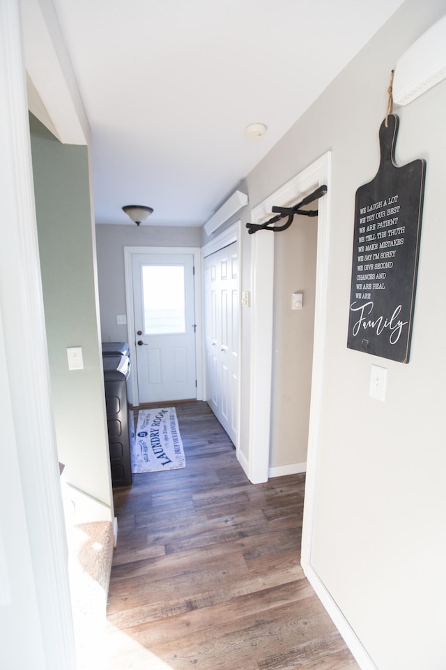 hallway featuring dark wood-type flooring and an AC wall unit