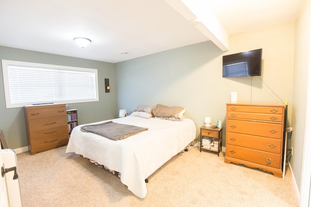 bedroom featuring light carpet and beam ceiling