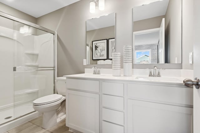 bathroom with tile patterned flooring, vanity, toilet, and an enclosed shower