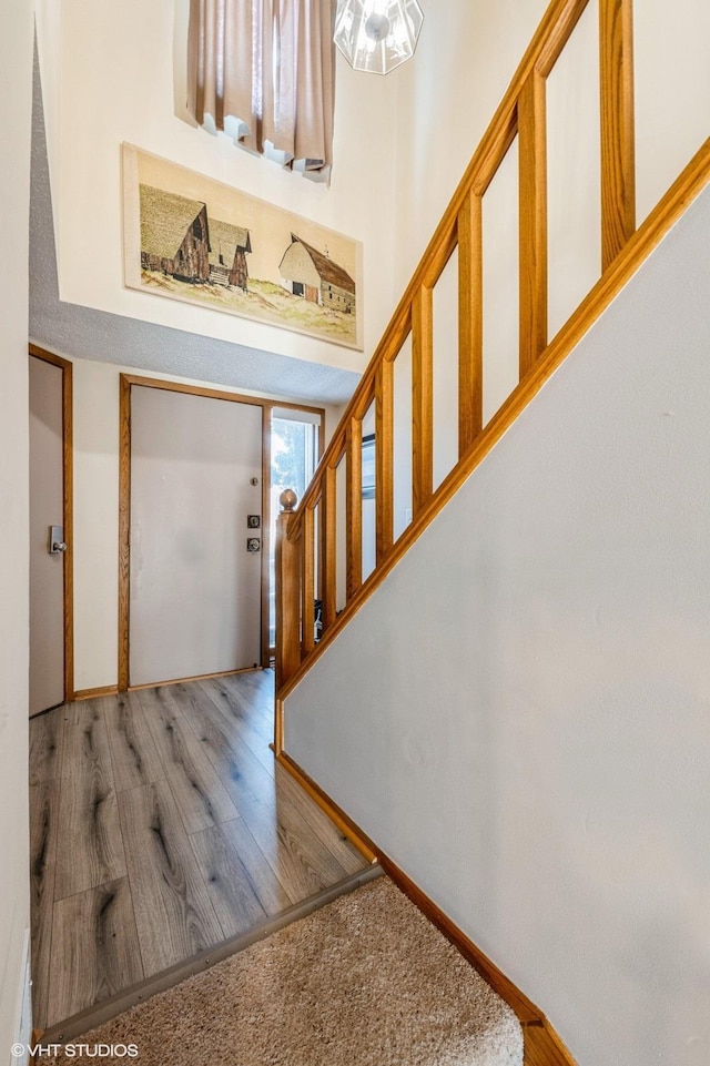 entrance foyer with baseboards, stairway, and wood finished floors