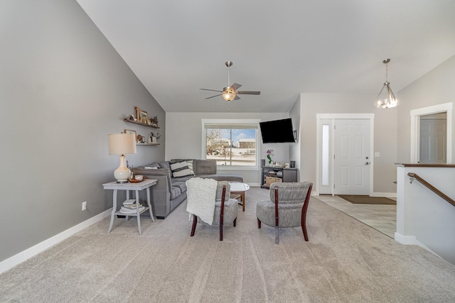 living room featuring ceiling fan with notable chandelier, lofted ceiling, and light colored carpet