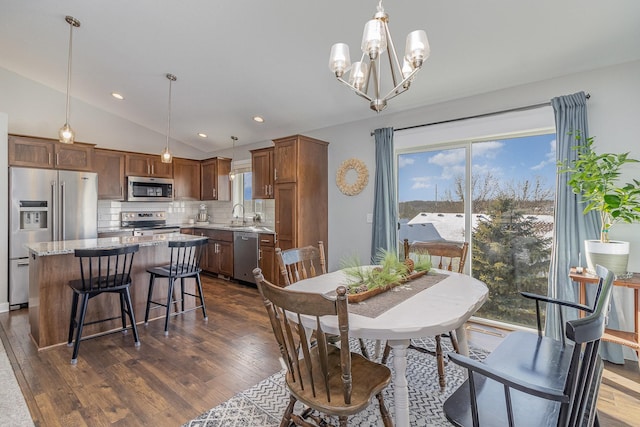 dining room featuring vaulted ceiling, a chandelier, dark hardwood / wood-style floors, and sink