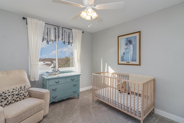 carpeted bedroom with ceiling fan and a nursery area