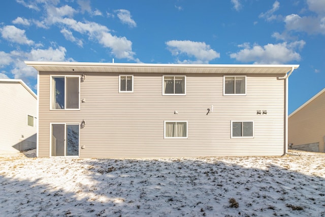 view of snow covered rear of property